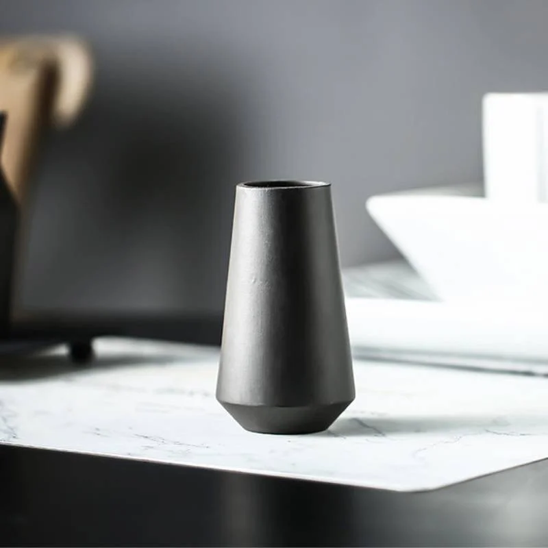 Close-up of a tapered black vase on a marble table
