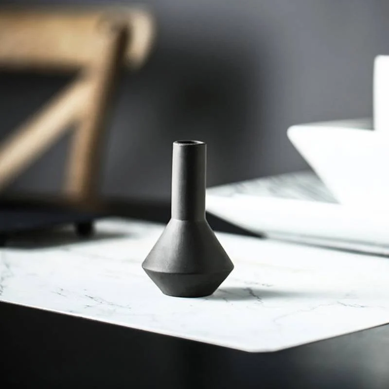 Close-up of a slim black vase with a narrow neck