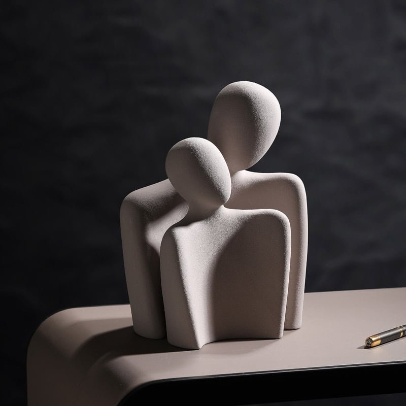 Grey abstract two-figure sculpture on a white background