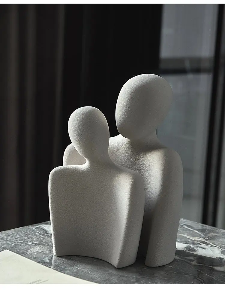Abstract two-figure sculpture in light grey on a marble side table
